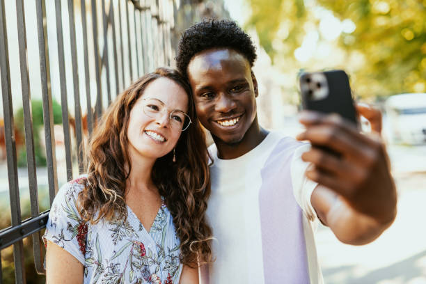 istock Millennial multiethnic couple using smart phone outdoors in the city 1455534399