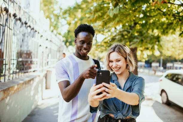 istock Millennials using smart phone outdoors in the city 1455534416