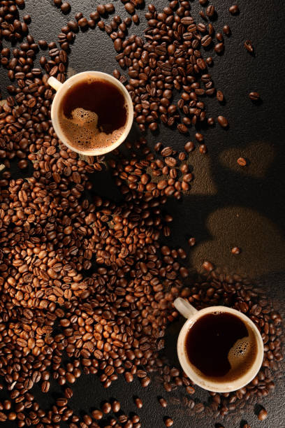 Coffee mug over coffee beans. Heart shaped stock photo