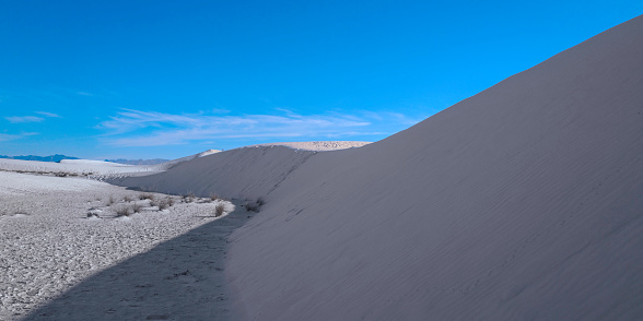 Curved silhouette lines of Gypsum Sand Dunes and the blue sky of White Sands National Park, New Mexico, USA