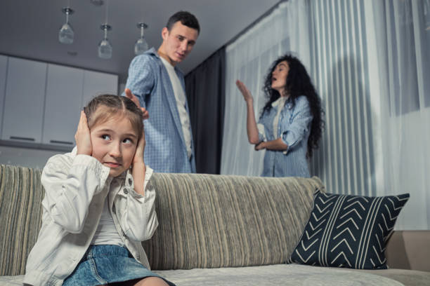 istock Junior schoolgirl sits closing ears against arguing parents 1455541397