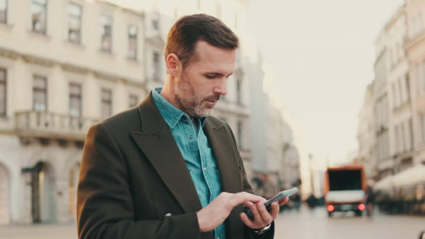 istock Middle aged man using map app on mobile phone on the old town background 1455543039