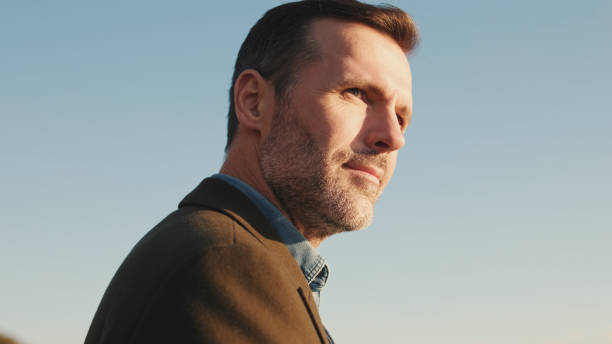 istock Close up, man looks around on blue sky background 1455543115