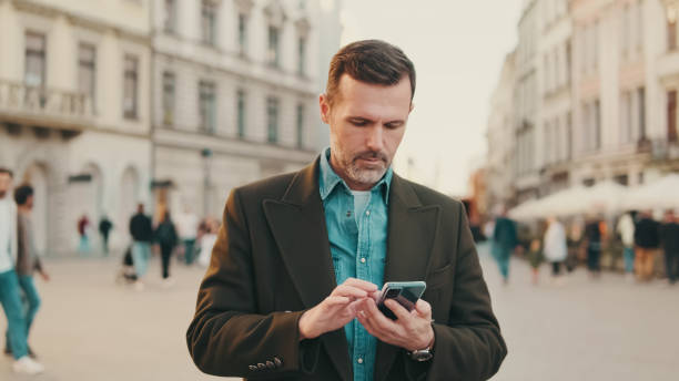 istock Middle aged man using map app on mobile phone on the old town background 1455543465
