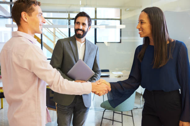 istock Two male colleagues welcome the visiting female manager in a modern office 1455543723