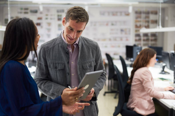 istock Two architects in the office in a lively conversation commenting on information on tablet device 1455543848