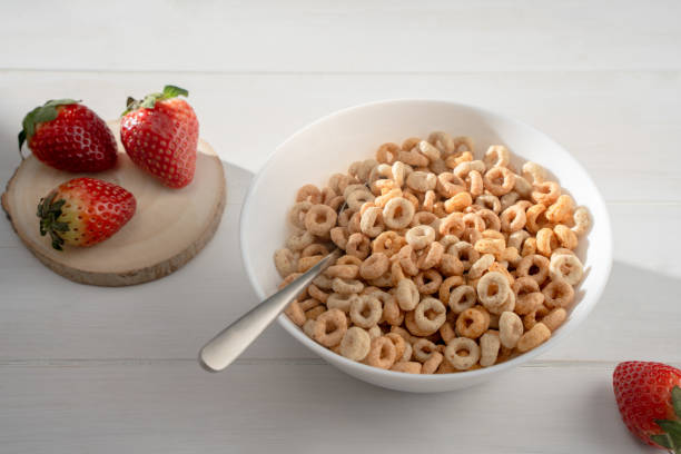 istock Cereal bowl with strawberries and spoon on a white table, top view, copy space 1455543888