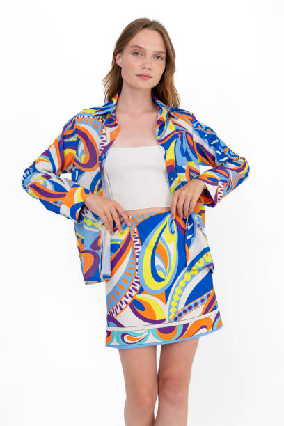 istock Blonde girl on a white background, wearing a multi-colored and patterned long sleeved shirt and short skirt and white bodysuit. 1455545235
