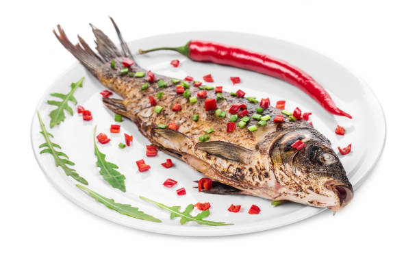 Grilled carp with vegetables on a plate. Isolated on a white background. Close-up.