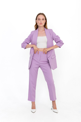 Young girl wearing purple sporty suit against white backdrop. Photomodel wearing jacket and trousers.