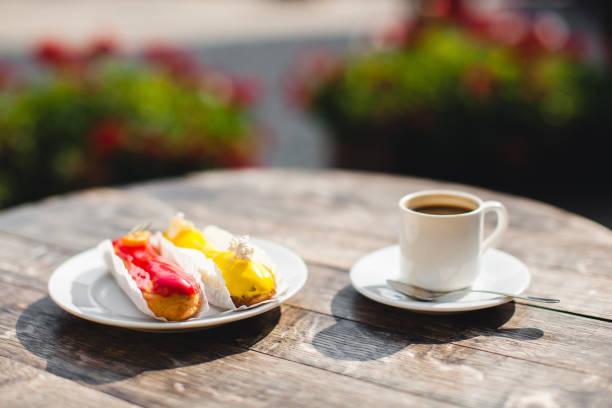 a mug of coffee on table and a delicious eclair on a plate