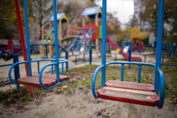 istock a lonely empty swing on a playground without people. 1455548472