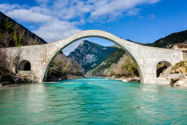 Photo of The great arched stone bridge of Plaka on Arachthos river, Tzoumerka, Greece.