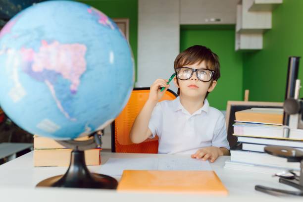 istock Boy studying at home and doing school homework. Distance learning online education. 1455553222