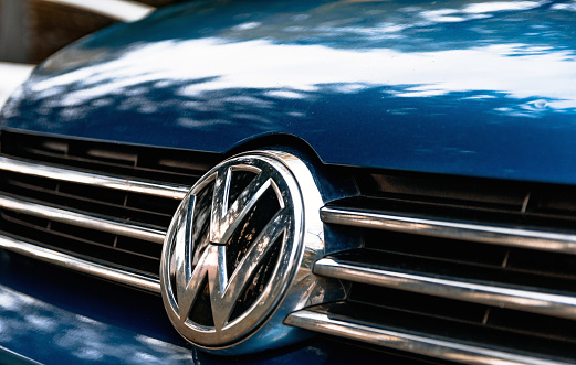 Ljubljana, Slovenia – December 05, 2021: A closeup of a Volkswagen logo on the grille of a blue car