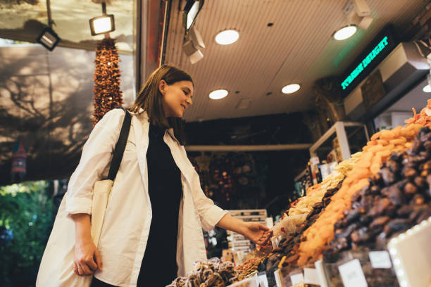 istock Woman on bazaar exploring spices, nuts and delight. 1455561688