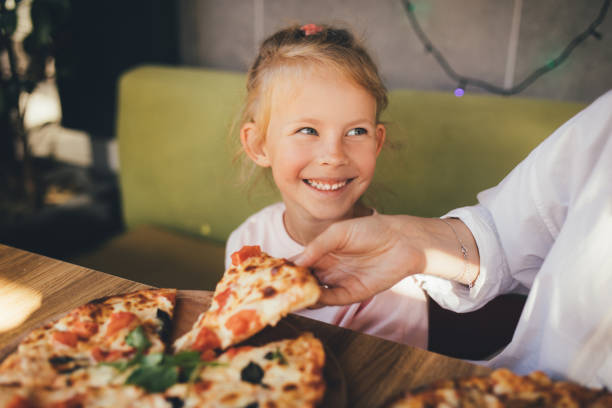 istock Mother and daughter eat pizza in a cafe. 1455561728