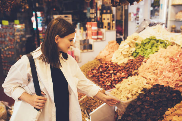 istock Woman on bazaar exploring spices, nuts and delight. 1455561736