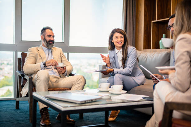istock Teamwork. Team discussing something and smiling while sitting at the modern business lounge. 1455563933