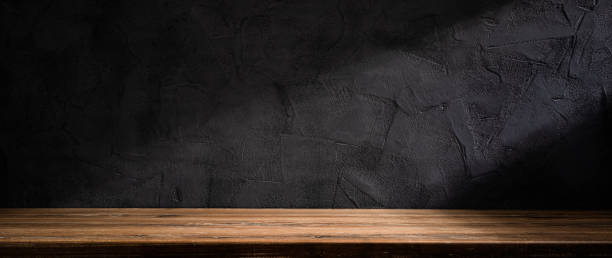 istock Wooden table or counter top with black stone wall background 1455564121