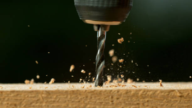 Freeze motion of a drill bit drilling into wood stock photo