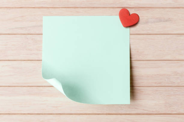 istock Blank sticky note with copy space and red heart on wooden background. Valentines day greeting concept 1455565770