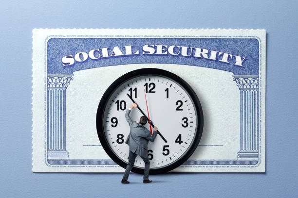 Man Holding Back Hands Of Time In Front Of Social Security Card stock photo