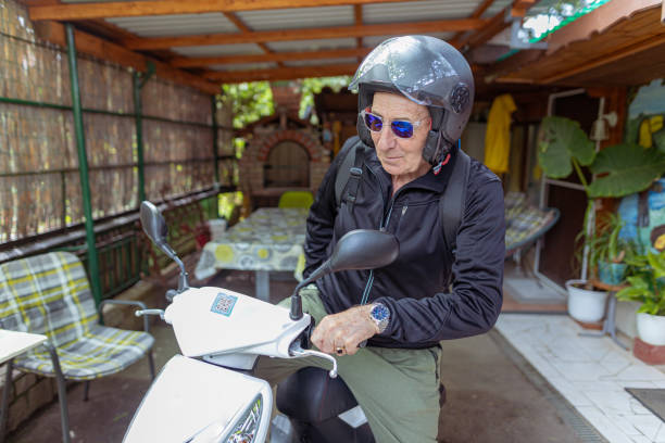 istock Senior man with a helmet riding a motorcycle 1455569061