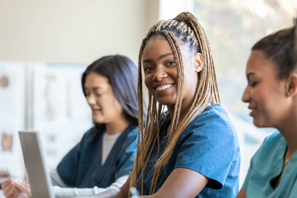 istock Beautiful young adult nursing student smiles while attending medical training class at university 1455572150