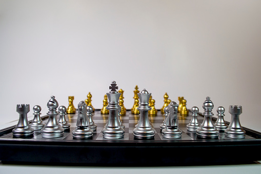 Vertical chess table seen in first person, silver pieces, white background