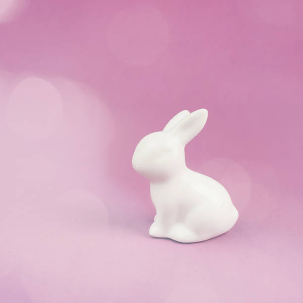 istock Easter bunny or rabbit sitting on a pink pastel colored background, spring holiday greeting card, bokeh light 1455574456