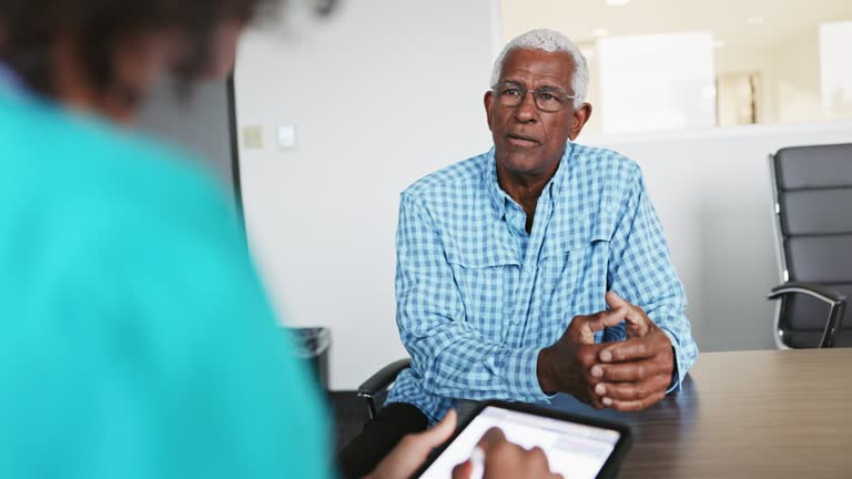 Nurse meeting with a senior black male patient