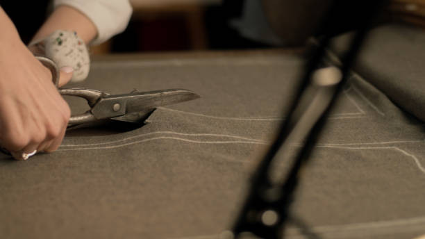 istock Female tailor cuts fabric according to sketch 1455582816