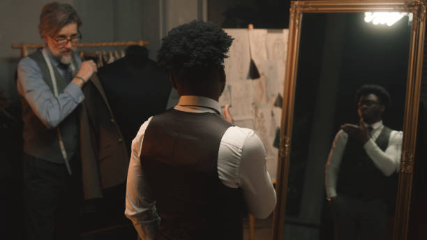 istock Tailor puts jacket on man in luxury clothing shop 1455583362