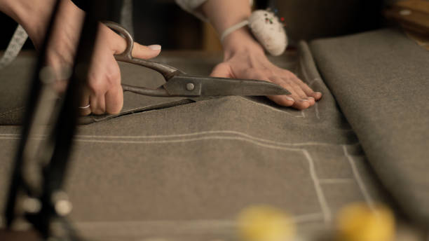 istock Female tailor cuts fabric according to sketch 1455584208