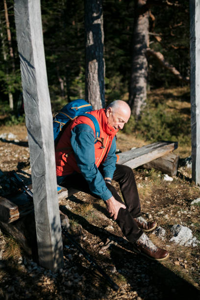 istock Senior man has sprained his knee while hiking on mountain 1455585629