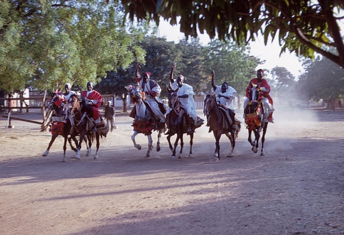 West Africa, North Cameroon, 1968. Fulani (Fulbe) horsemen in North Cameroon galloping down a village street.