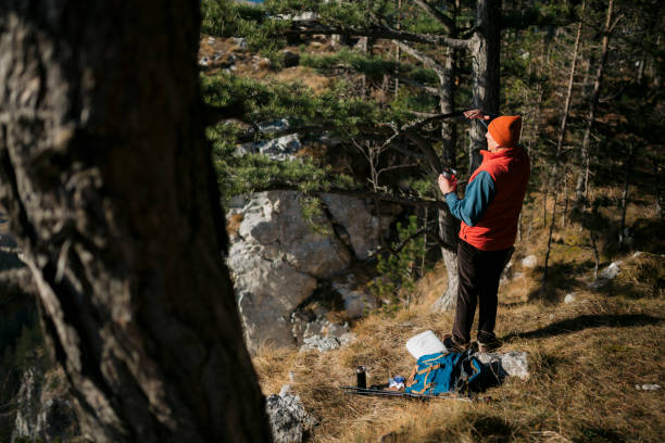 istock Retired man on hike looking at view in distance while taking refreshment break 1455585930