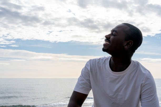 istock Cheerful black man relaxing near sea 1455586779