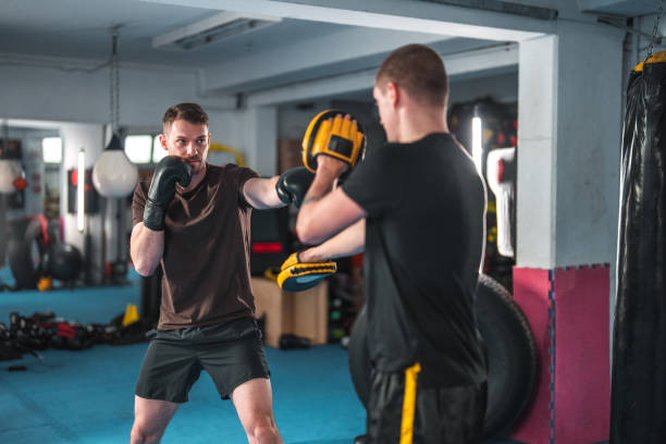 Caucasian Males At Boxing Practice Caucasian male boxers practicing in a gym. Working hard in a boxing gym, sweating. fighting stance stock pictures, royalty-free photos & images