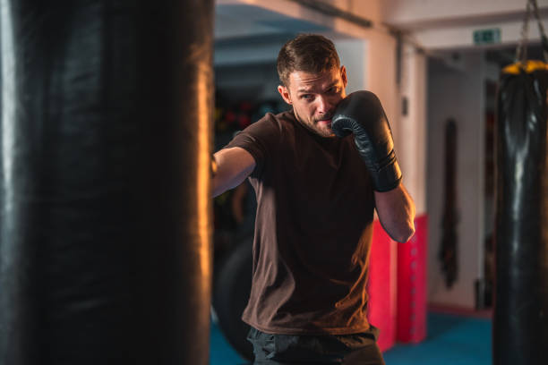 istock Young Caucasian Male Exercising With A Punching Bag 1455587370