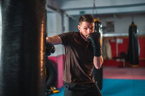 Young man boxing at the punching bag