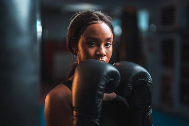 Headshot of a confident young multi-ethnic female boxer wearing boxing gloves and sports clothes