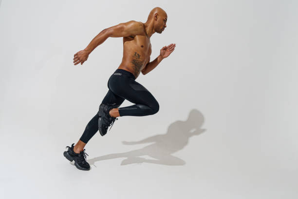 istock Professional male athlete running isolated on white studio background with shadows 1455589120