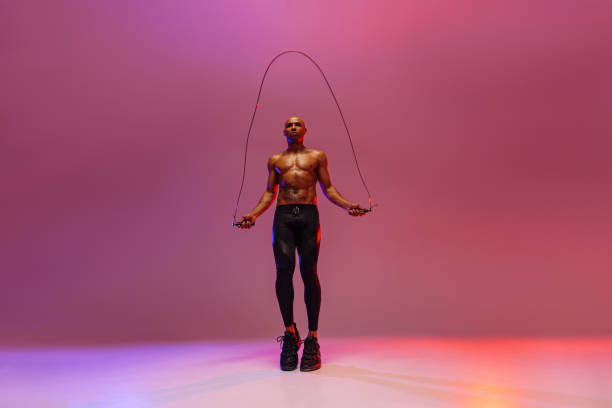 istock Man skipping with jump rope on studio background. Strength and motivation. Best cardio workout 1455589759