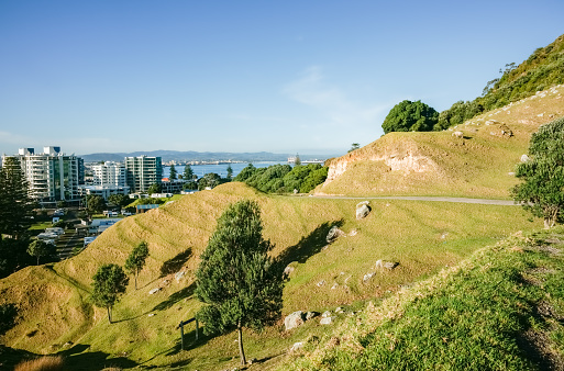 Slope of Mount Maunganui with walking track and horbour and town in background, Tauranga New Zealand.