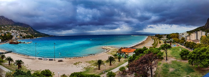 A panoramic shot of a coastline under a cloudy gloomy sky