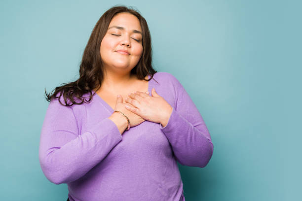 istock Thankful young woman touching her heart 1455591580