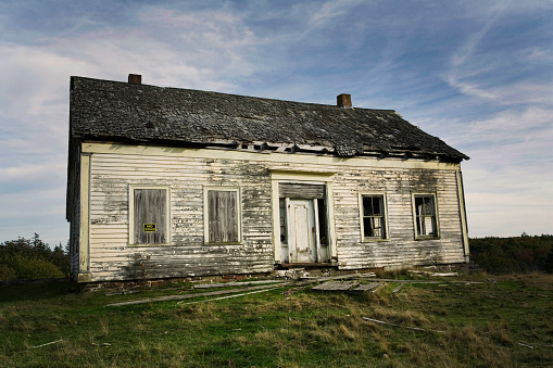 An old abandoned wooden white clapboard house.