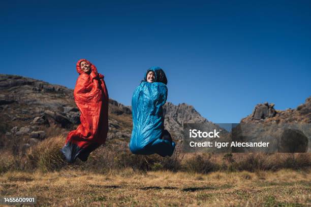 Women Jumping On Sleeping Bag Stock Photo - Download Image Now - Humor, Sleeping Bag, Camping